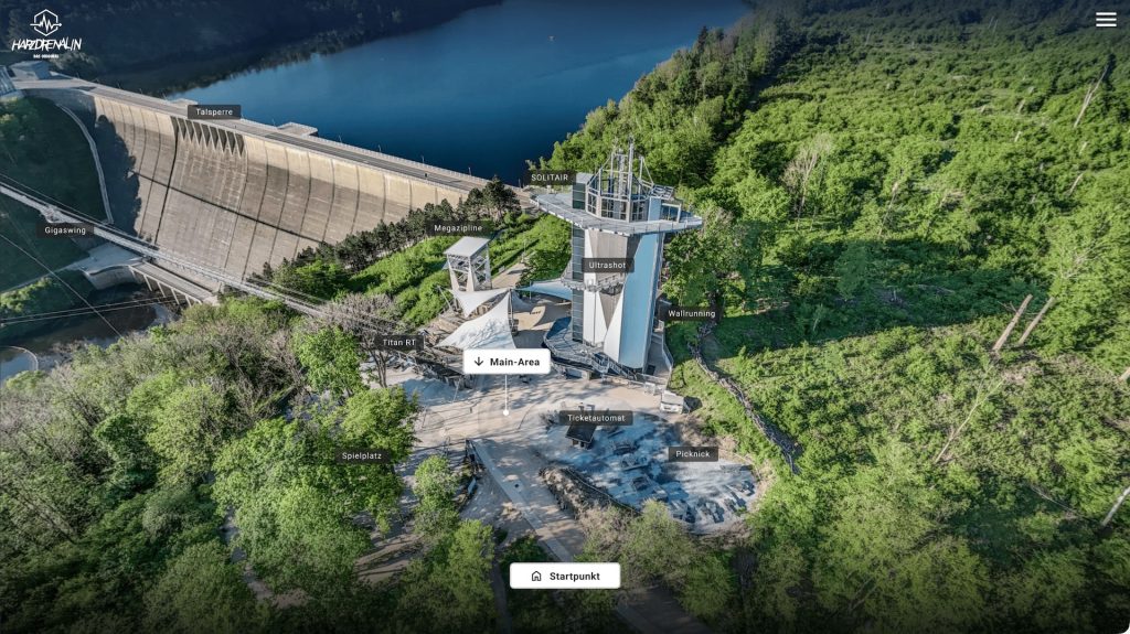Screenshot of the Harzdrenalin 360° tour showing a drone view over the adventure park beside a dam and lake, with labeled hotspots for attractions (e.g., Megazipline, Ultrashot) and a “Main-Area” button.